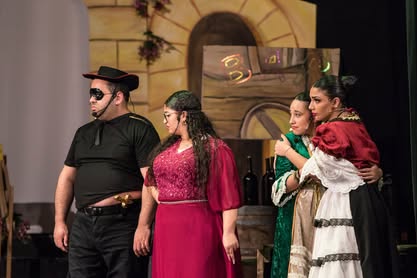 A scene from the Zorro pantomime featuring four actors in costume during a theatrical performance. Actors performing in Zorro pantomime on stage.