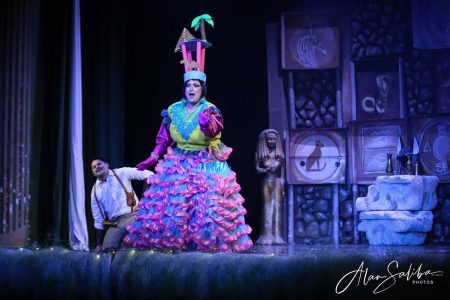 A performer in a bright, elaborate costume performs in the pantomime "Il-Mummja" during a theatrical show. Vibrant scene from the pantomime "Il-Mummja" featuring a colourful performer in elaborate costume on.