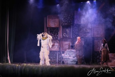 A theatrical performance titled "Il-Mummja" featuring actors in elaborate costumes on stage. Pantomima scene with actors in costume on stage at Fondazzjoni Teatrali Silvio Fleri Soler.