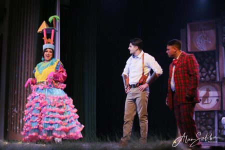 Performers in colourful costumes act out a scene from Il-Mummja pantomime on stage. Pantomima scene with performers from Il-Mummja.