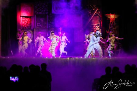 A lively scene from the pantomime "Il-Mummja" at Fondazzjoni Teatrali Silvio Fleri Soler. Performing artists in colourful costumes on stage during a pantomime show.