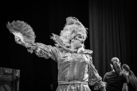 A performer dressed as Zorro in a theatrical pantomime, engaging the audience with expressive gestures and costume. Zorro pantomime performance in theatre.