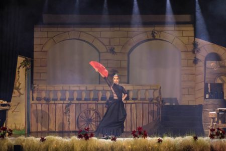 Pantomime "Zorro" performance at Fondazzjoni Teatrali Silvio Fleri Soler. A performer in a black dress holding a red umbrella on stage.