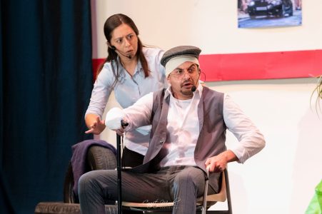 Actors engaging in a humorous theatrical performance on stage. Performers in a comedy scene during Serata Daħk! event.