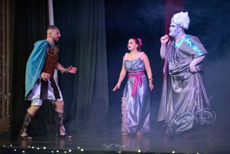 Actors performing a theatrical scene in colorful costumes during a live show. Theatre performance with actors in elaborate costumes on stage.