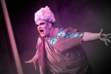 A performer dressed in elaborate costume and makeup, expressing intense emotion during a theatrical production at Fondazzjoni Teatrali Silvio Fleri So. Actor in theatrical costume performing passionately on stage.