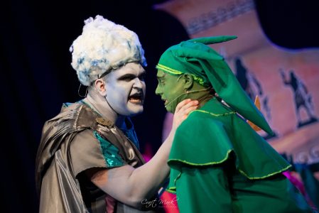 Two actors engaged in a theatrical duel, portraying intense emotions during a live performance. Actors in dramatic theatre duel performance on stage.