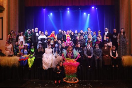 Cast of Korps Brajd in vibrant costumes on stage after their pantomime performance at Fondazzjoni Teatrali Silvio Fleri Soler. Group photo of performers in colourful costumes after pantomime show.
