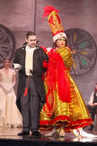 A colourful scene from the Korps Brajd pantomime, showcasing expressive costumes and theatrical acting. Performers in elaborate costumes during a lively pantomime scene.