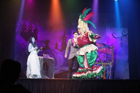 A lively scene from the pantomime "Korps Brajd" showcasing theatrical costumes and stage design. Colourful pantomime scene featuring performers in elaborate costumes on stage.