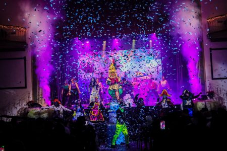 A lively pantomime titled "Korps Brajd" performed at Fondazzjoni Teatrali Silvio Fleri Soler, with dynamic lighting and confetti. Colourful theatrical scene featuring performers on stage during a pantomime show.